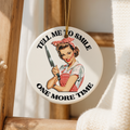 Decorative keepsake with a vintage-style illustration of a woman holding a knife, hanging on a wooden frame.