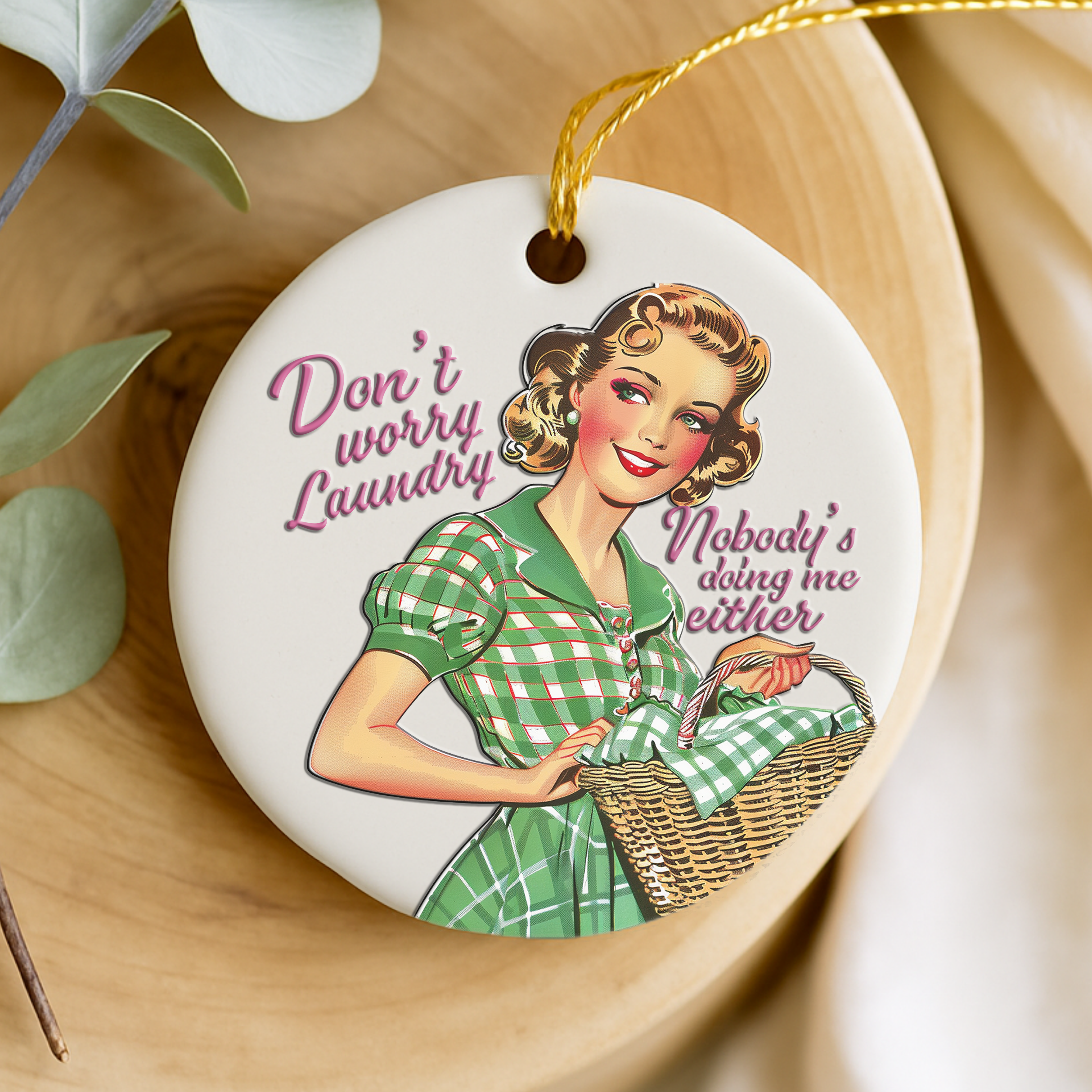 Decorative keepsake with a vintage-style illustration of a woman in a green dress holding a laundry basket, with text 'Don't worry, laundry. Nobody's doing me either.
