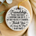 Decorative keepsake with humorous text on a wooden surface with a leaf branch.