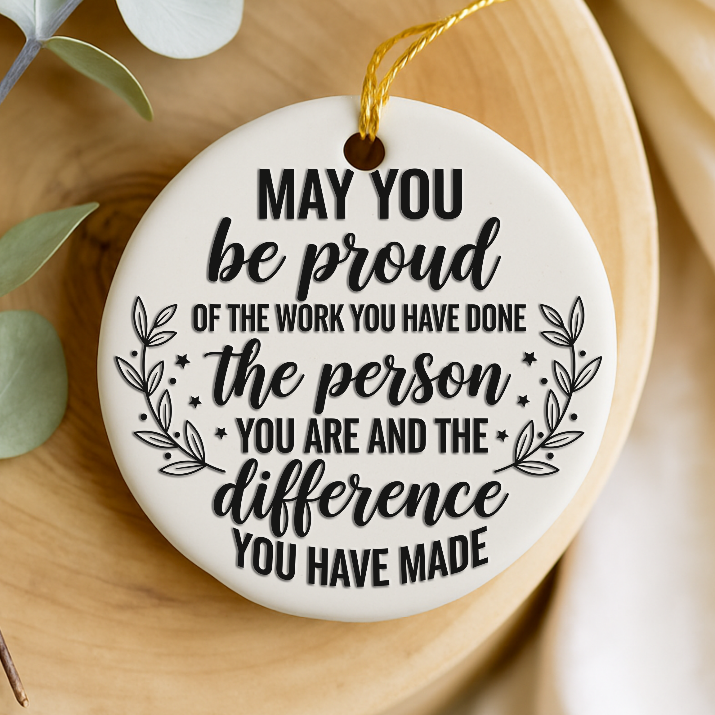 Decorative keepsake with motivational quote on a wooden surface with greenery